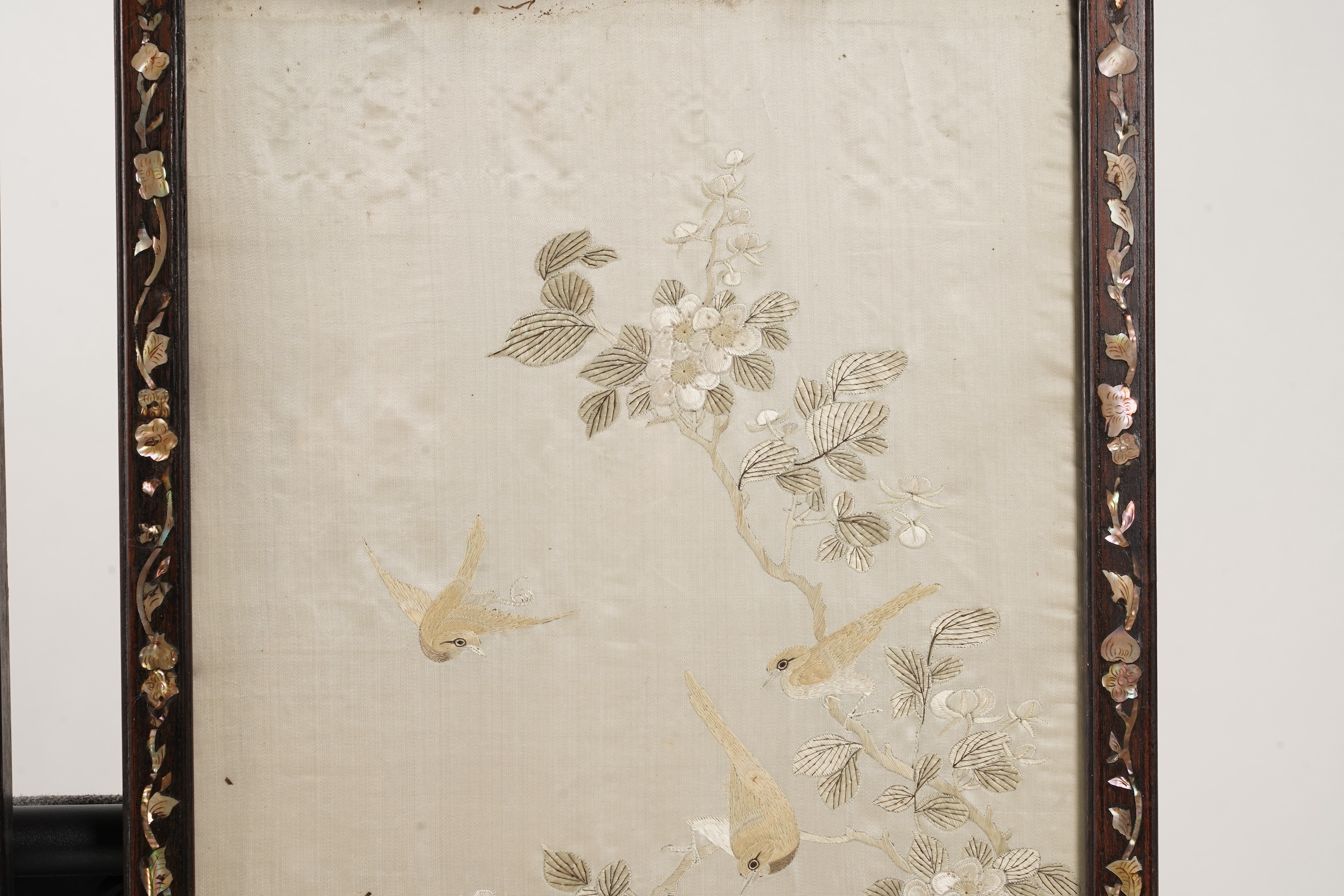 A pair of Chinese embroidered silk ‘bird’ panels, in mother-of-pearl inlaid hongmu frames, late 19th/early 20th century